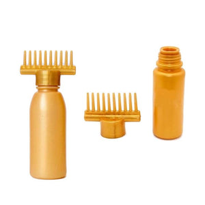 An empty golden-colored hair oiling bottle with a brass applicator and a comb attachment.