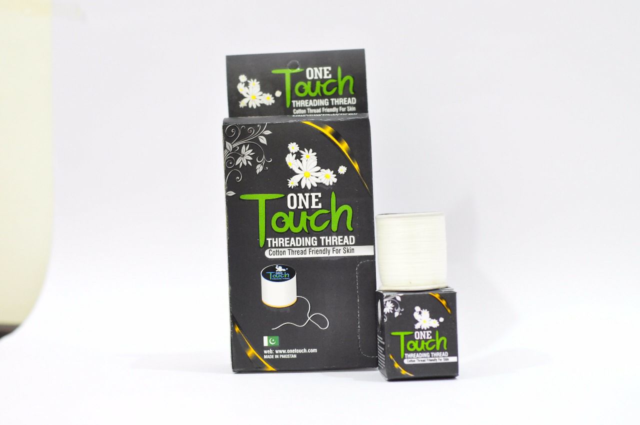 A box and a roll of threading thread with packaging labeled 'One Touch' by Oxolane. The thread is meant for hair removal and is made from cotton.
